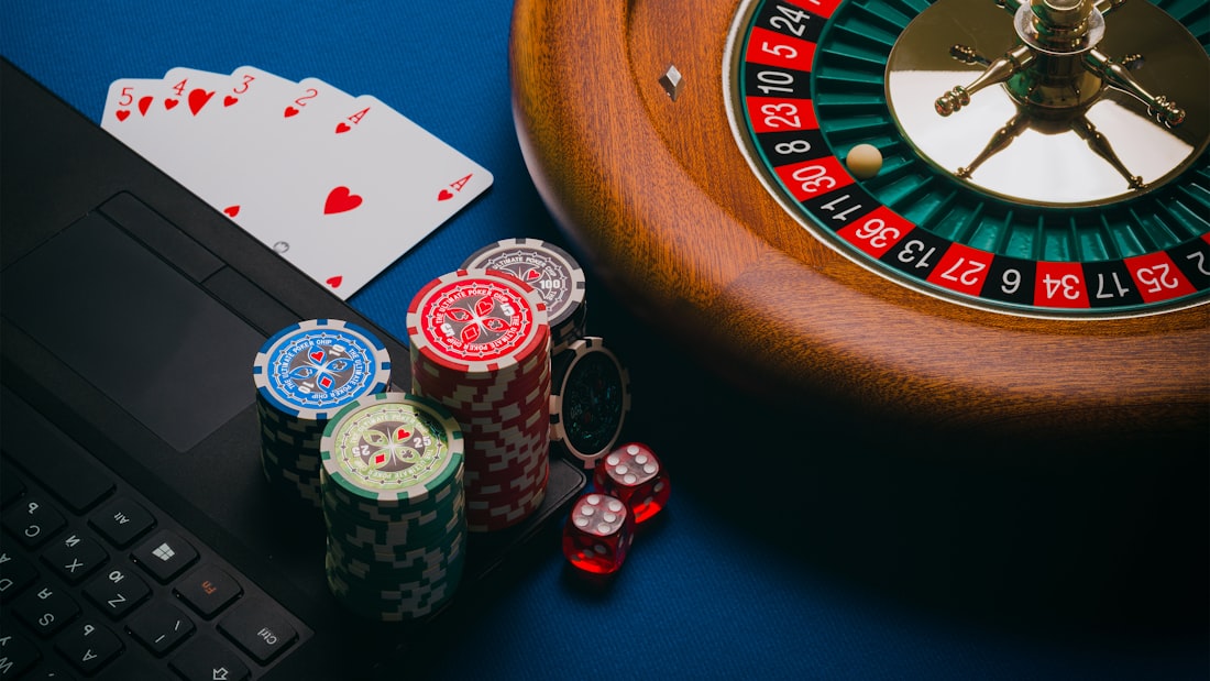 Roda roulette dan tumpukan chip warna di atas meja kasino