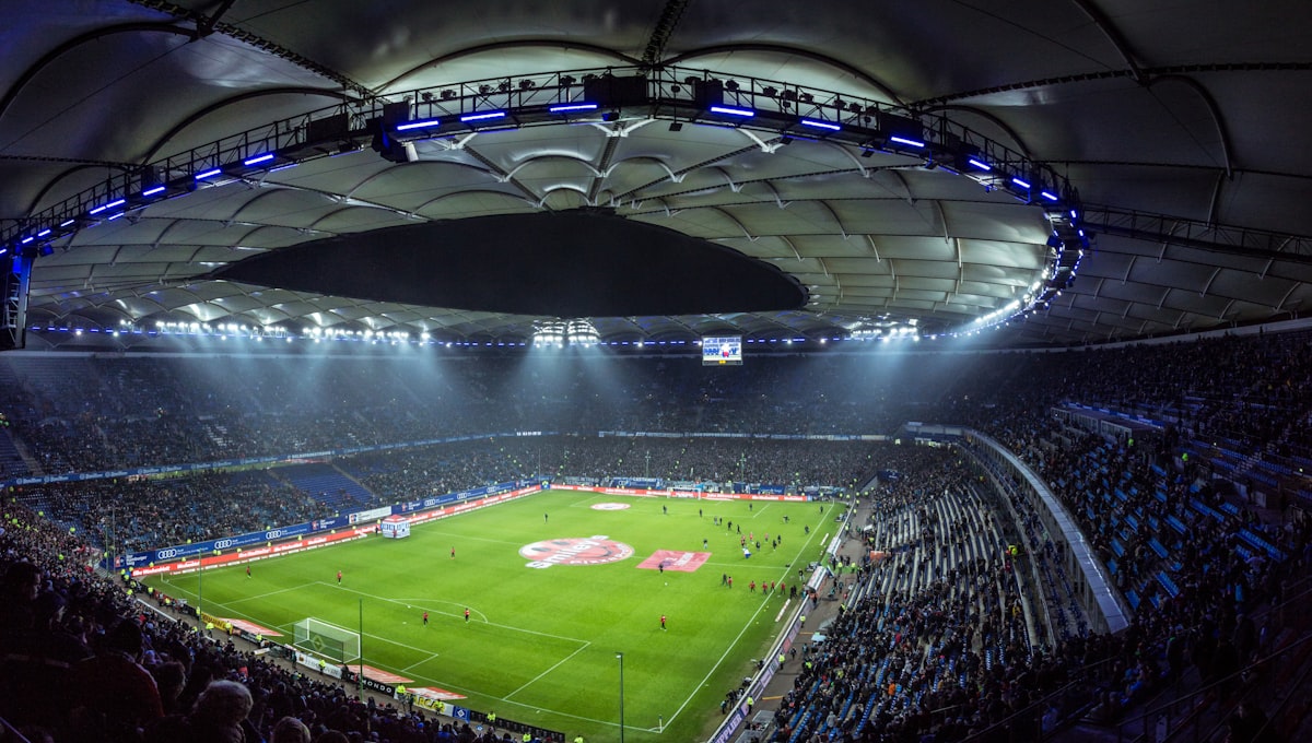 Stadion bola dengan sorot lampu menyala sebelum pertandingan